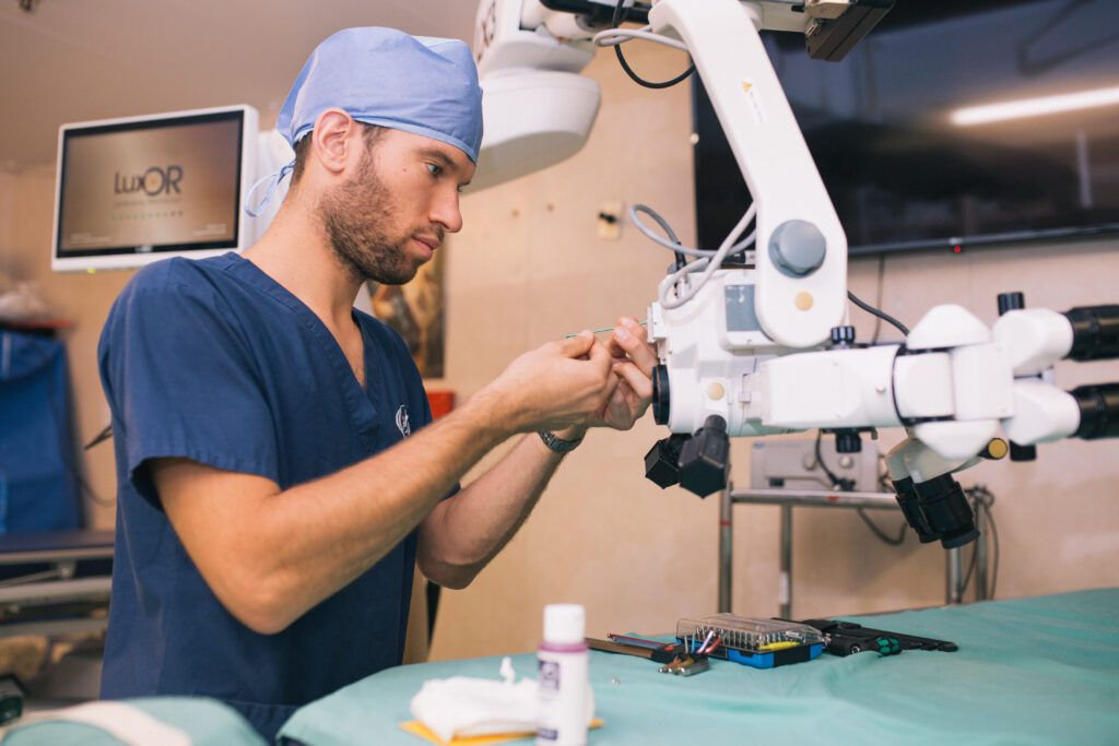 A hospital technician inspecting or servicing medical equipment in a clinical setting.