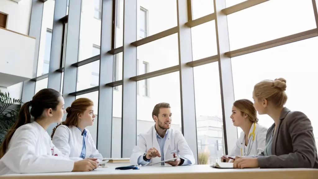 Meeting team and doctors in discussion in the hospital conference room for collaboration on how to set up a hospital