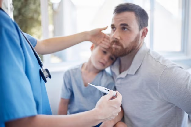 Clinic nurse using a thermometer on a child